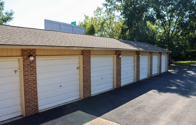 a row of white garage doors on a brick building