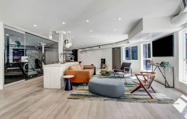 a spacious living room with white walls and hardwood flooring