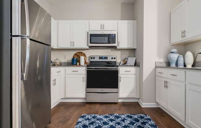 a kitchen with stainless steel appliances and white cabinets