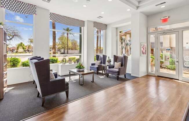 A waiting room with a view of the outdoors through the windows.