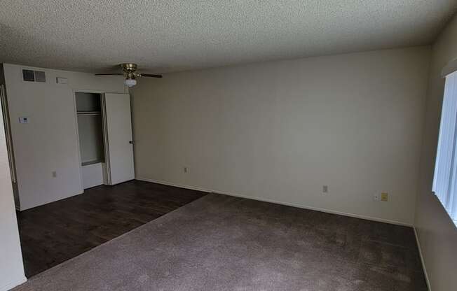 Living room and dining room area with large front window at Magnolia Apartments in Riverside, California.