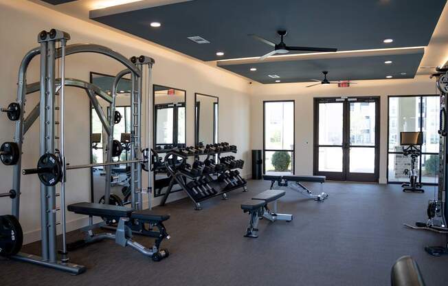 A spacious gym with a variety of equipment including a squat rack, bench, and weights.