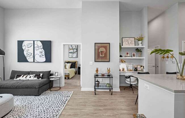 A living room with a grey couch and a white wall.