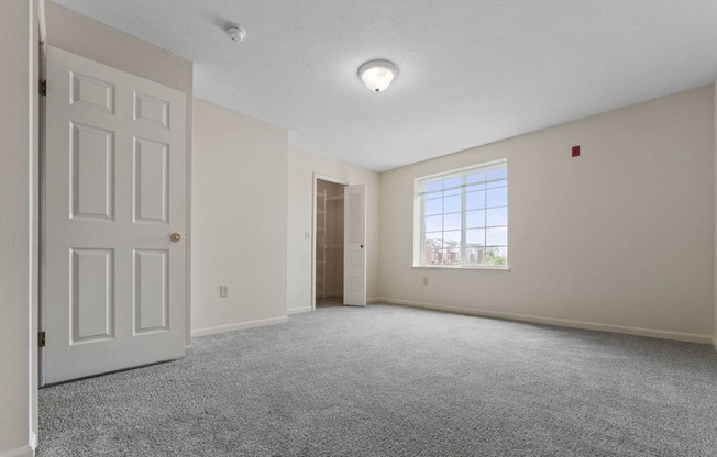 large bedroom with a ceiling fan and a door to a walk-in closet  at Hunters Pond Apartment Homes, Champaign, Illinois