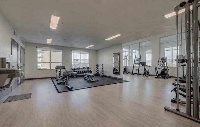 A spacious gym with a variety of equipment and a large mirror on the wall.