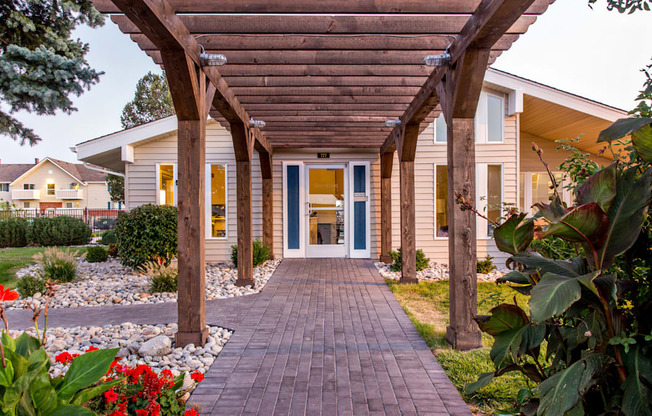 Covered pergola walkway leading to leasing office at Aurora Meadows apartments.
