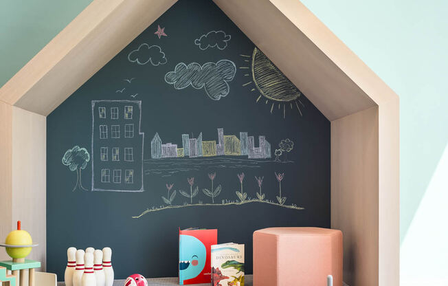 a childs playroom with a chalkboard wall and a table and chairs at The Lively, Jersey City, NJ 07302