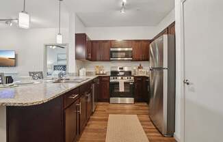 A kitchen with a refrigerator, stove, and microwave.
