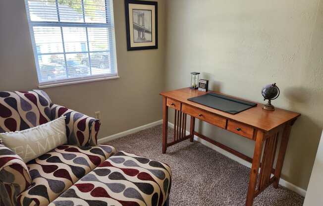 a living room with a couch and a desk with a laptop