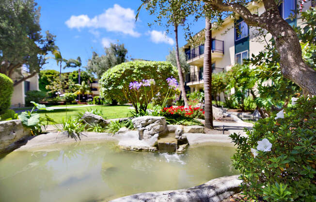 a spa with a fountain in the middle of a garden at Willow Tree Apartments, Torrance