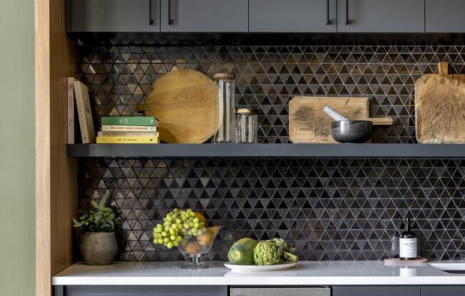 a kitchen with gray cabinets and a stainless steel oven and sink