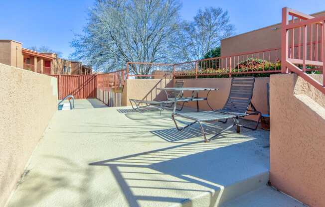 a patio with a table and chairs next to the pool