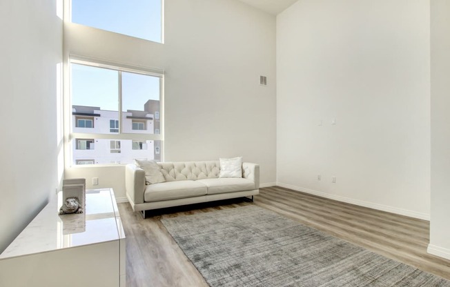 Living and sleeping area of a studio penthouse, large windows, high ceilings, Laminate flooring