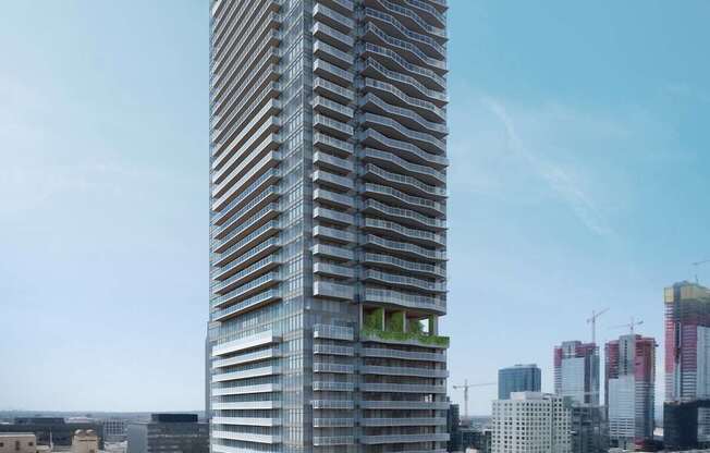 A tall, modern building with a glass facade stands in the middle of a cityscape.