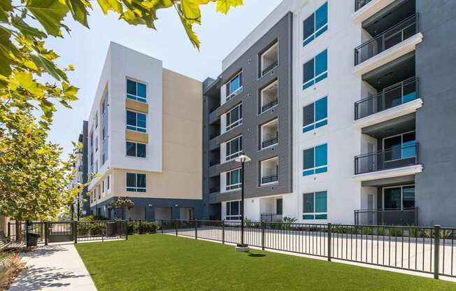 A modern apartment building with a green lawn in front.