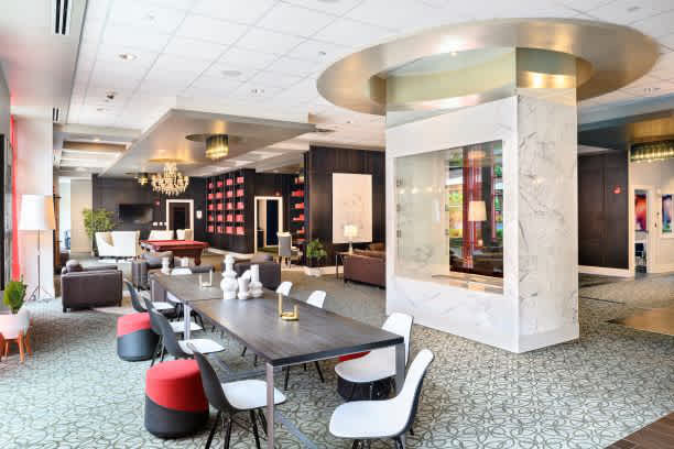 A modern dining area with a long table surrounded by chairs.