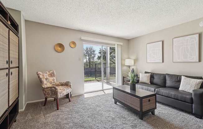 A living room with a chair, a sofa, and a coffee table.
