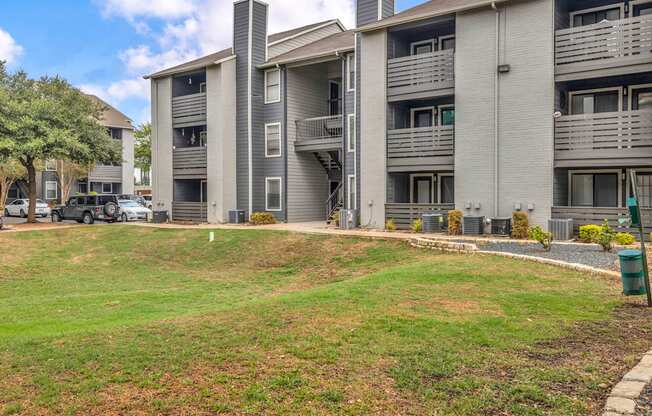 an apartment building with a green lawn in front of it