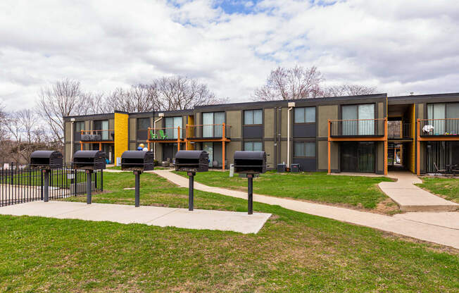 A modern building with a yellow and grey exterior and a black fence in front.