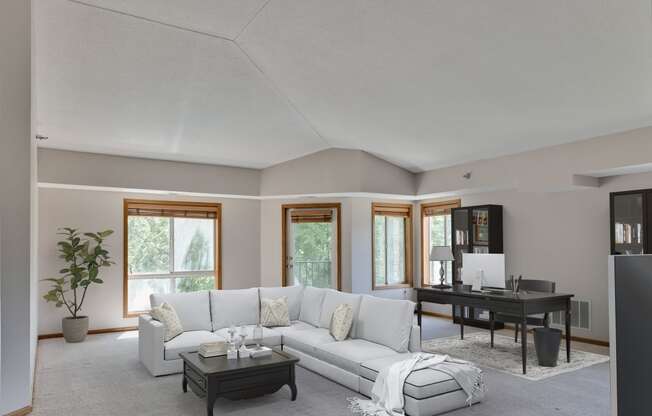 a living room with a white couch and a black table and a piano