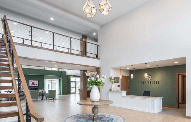 A reception area with a white reception desk and a staircase.