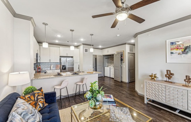 a living room and kitchen with a ceiling fan