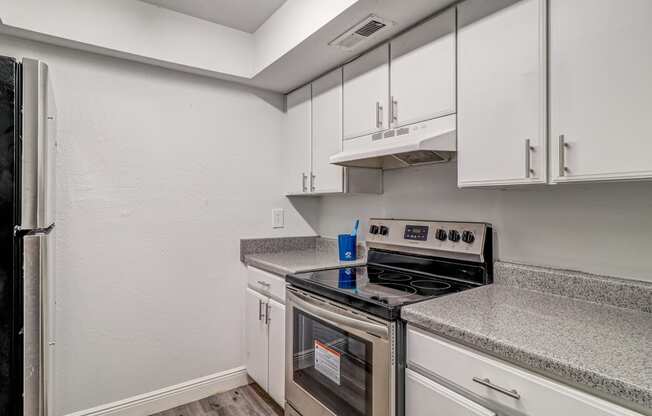 a kitchen with white cabinets and stainless steel appliances