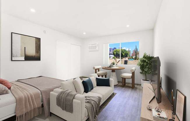 A bedroom with a bed, couch, and television.