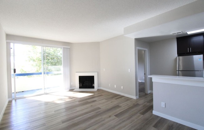 an empty living room with wood floors and a fireplace