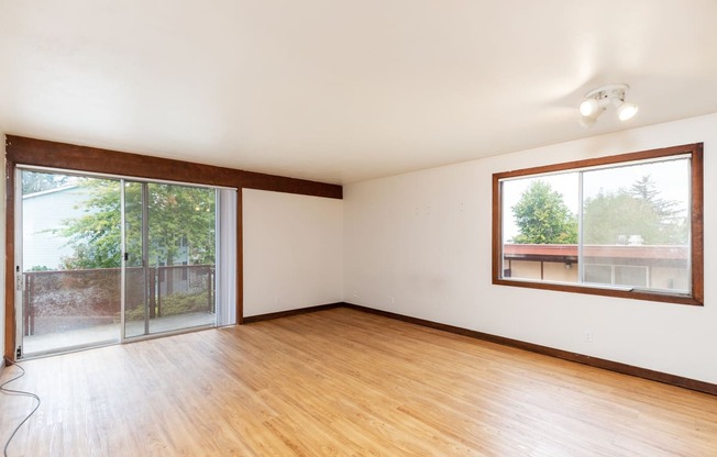 an empty living room with wood floors and a sliding glass door