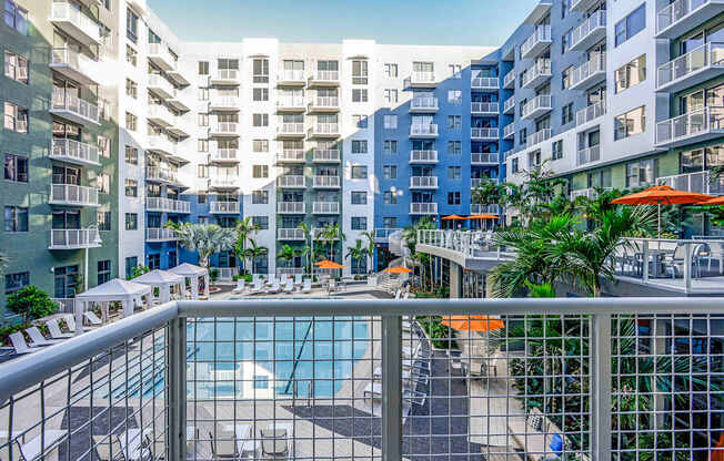 A view of a pool area from a balcony of a residential building.