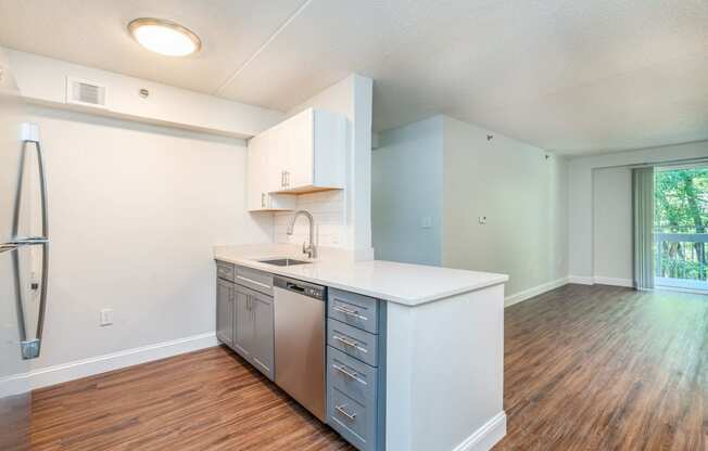 an empty kitchen with a counter top and a stainless steel refrigerator