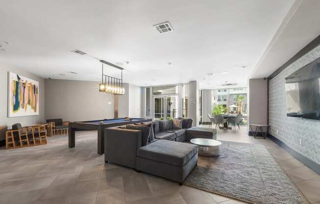 a living room filled with furniture and a pool table