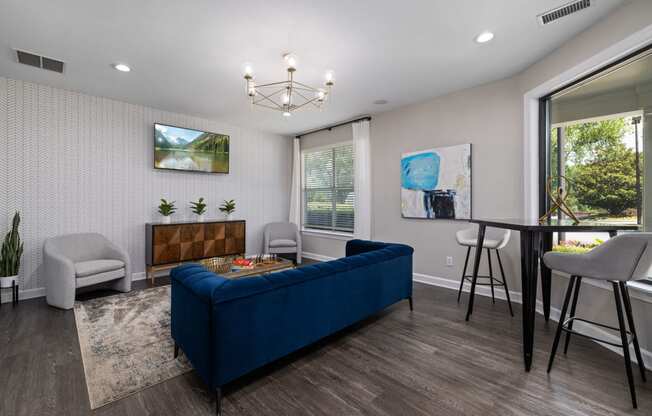 a living room with a blue couch and a table and chairs