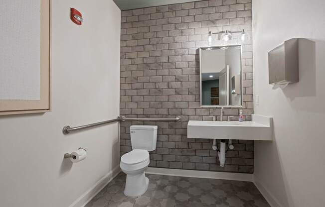 Flatiron West Trade Apartments office bathroom with stone wall