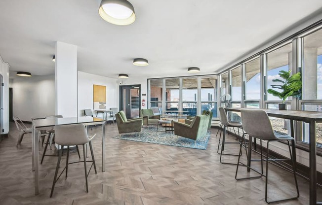 a living room with tables and chairs and a dining room with windows