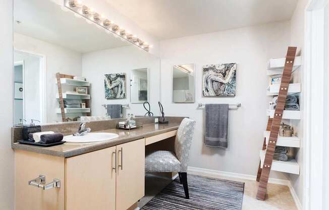 A bathroom with a vanity, a chair, and a mirror. at La Jolla Crossroads Apartments, San Diego, CA, 92122