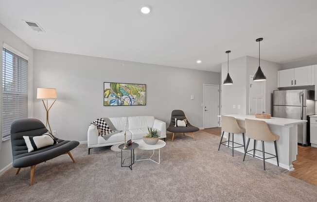 an open living room and kitchen with a couch and chairs