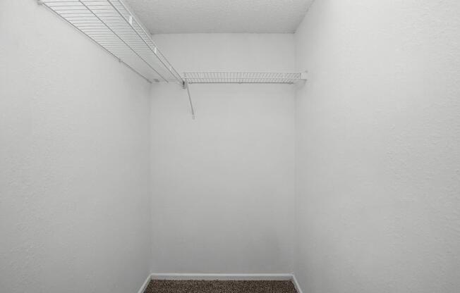 an empty room with a white wall and a carpet in it