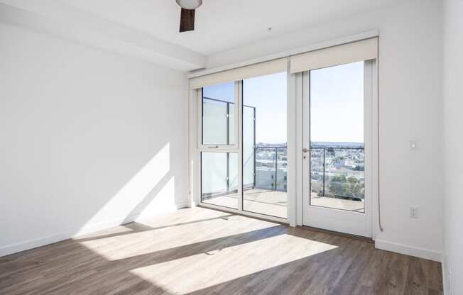 a living room with glass doors and a view of the city