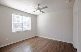 a bedroom with a ceiling fan and a window at 55 Fifty at Northwest Crossing, Texas