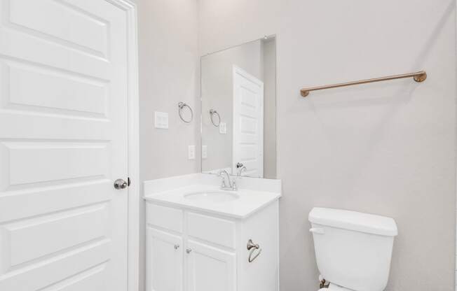 a bathroom with a sink toilet and mirror