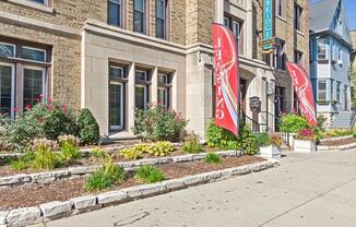 a sidewalk in front of a building with red flags