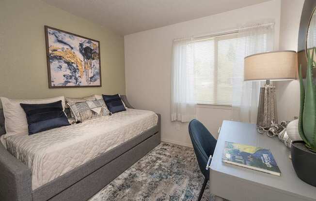 A bedroom with a bed, desk, and chair at Autumn Oaks Apartments, Roseville, CA, 95678