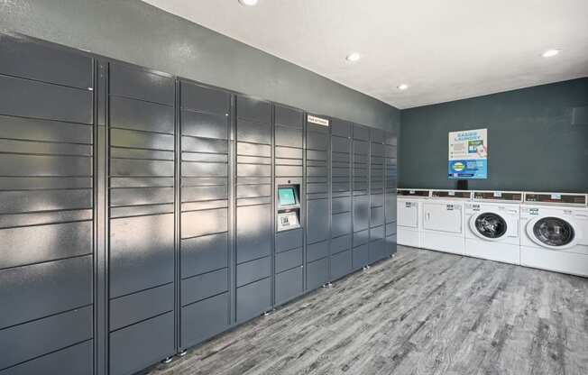 a laundry room with gray lockers and white washers and dryers