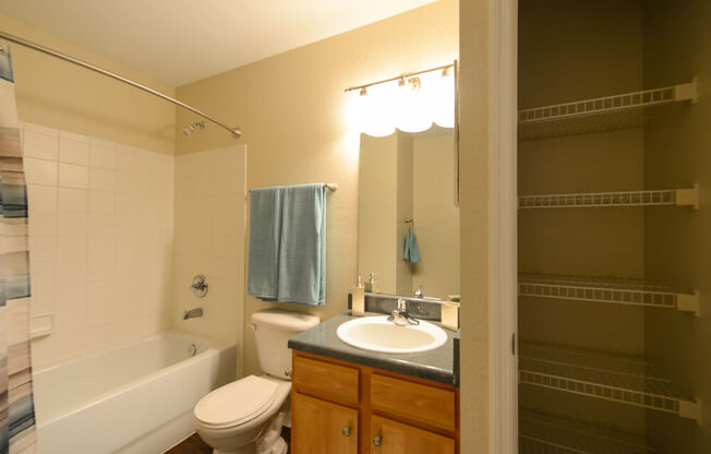 A bathroom with a toilet, sink, and bathtub.
