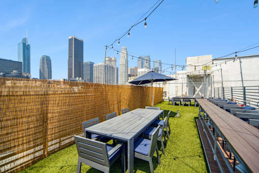 A patio with a table and chairs overlooking a city skyline.