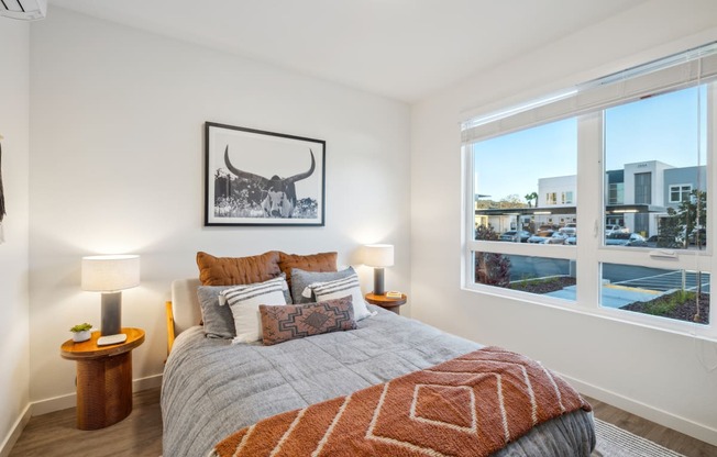 a bedroom with a bed and a window with a city view