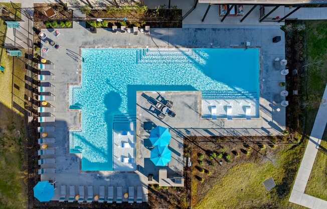 An aerial view of a swimming pool surrounded by a deck and a grassy area. at Bridge at Tech Crossing, Austin, 78753