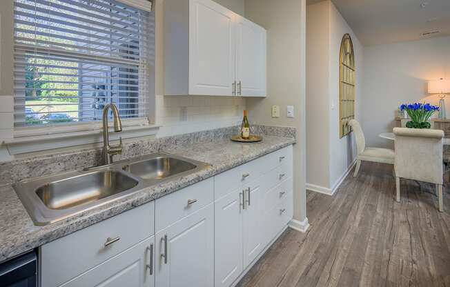 white kitchen cabinets and natural light filled kitchen with hardwood floors at Stone Ridge apartments Charlotte